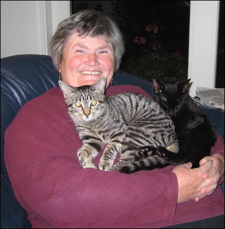 Woman with tabby and black cats on her lap